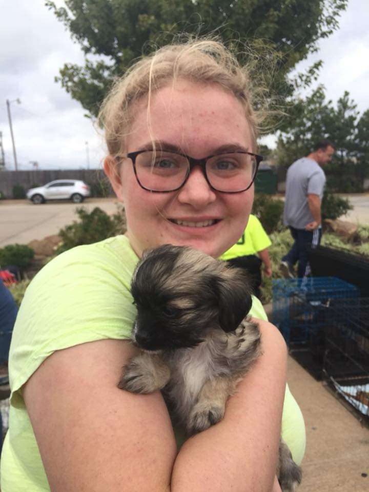 A blonde girl (the author) holding Ax as a puppy.